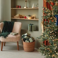 Stylish cozy home interior decorated for Christmas. Christmas tree and wrapped gifts in a modern living room.